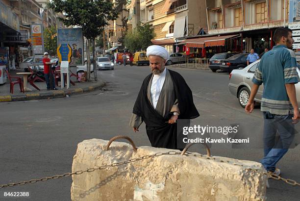 Shia cleric in a turban crosses the road in Haret Hreik, in the southern suburbs of Beirut, Lebanon.