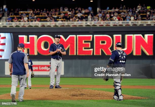 Travis Wood of the San Diego Padres reacts as manager Andy Green and catcher Austin Hedges head to the mound to relieve him from the game against the...