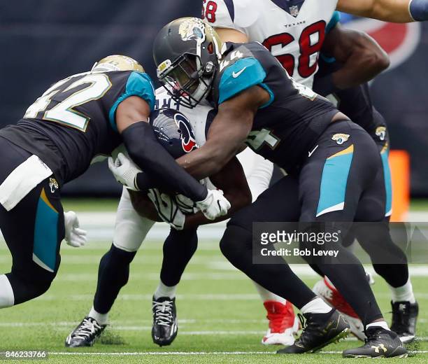 Tyler Ervin of the Houston Texans is tackled by Myles Jack of the Jacksonville Jaguars and Barry Church at NRG Stadium on September 10, 2017 in...