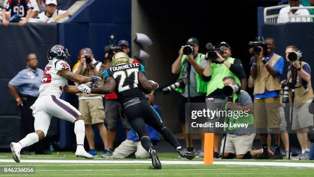 Leonard Fournette of the Jacksonville Jaguars runs for the pylon as Eddie Pleasant of the Houston Texans attempts to make a tackle at NRG Stadium on...