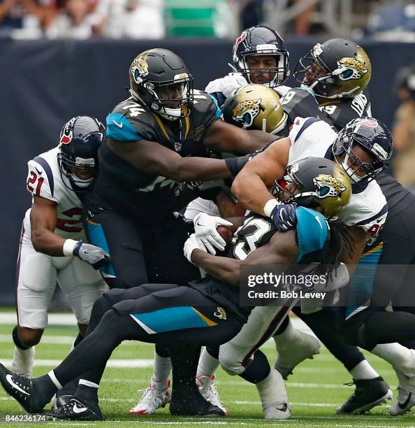 Chris Ivory of the Jacksonville Jaguars is tackled by Christian Covington of the Houston Texans at NRG Stadium on September 10, 2017 in Houston,...