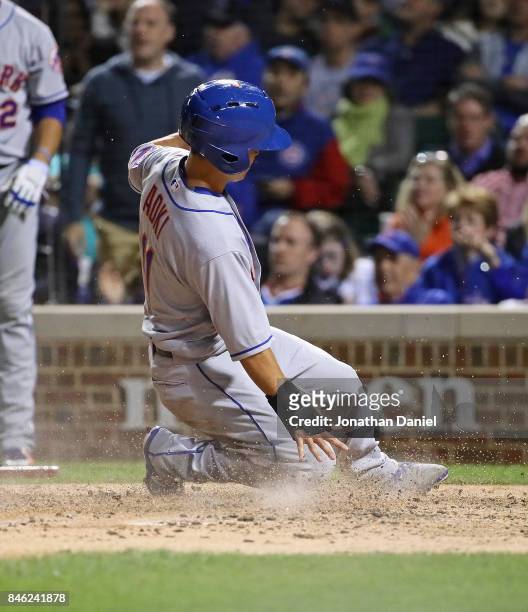 Norichika Aoki of the New York Mets slides in to score a run in the 5th inning against the Chicago Cubs at Wrigley Field on September 12, 2017 in...