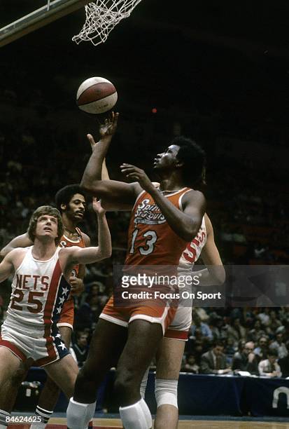 Moses Malone of the Spirits of St. Louis battles for position under the basket with Kim Hughes and Billy Schaeffer of the New York Nets during a...