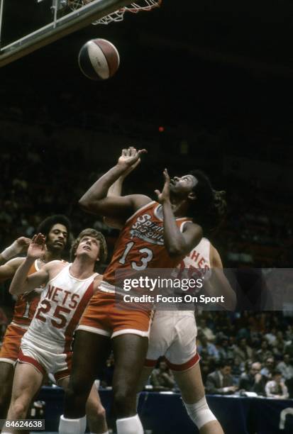 Moses Malone of the Spirits of St. Louis battles for position under the basket with Kim Hughes and Billy Schaeffer of the New York Nets during a...