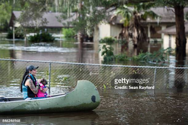 Woman and her dog navigate floodwaters caused by Hurricane Irma on September 12, 2017 in Middleburg, Florida, United States. The storm brought...