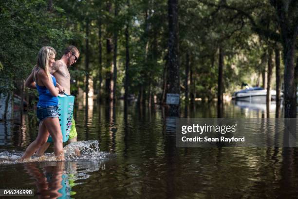 Lindsey Brown, left, and Christian Treadwell evacuate their neighborhood inundated by flood waters caused by Hurricane Irma September 12, 2017 in...