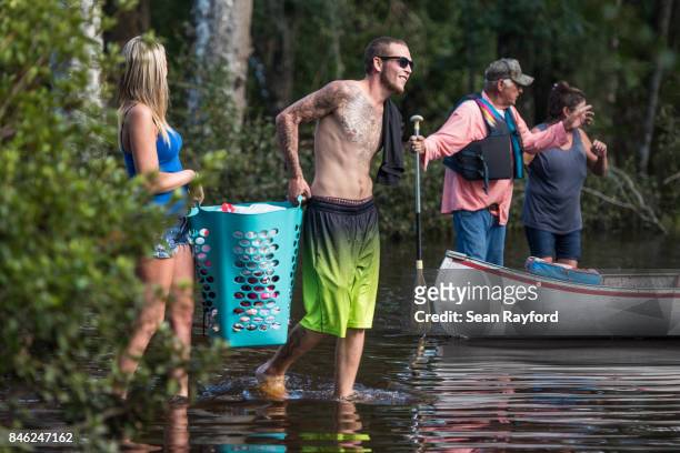 Christian Treadwell carries personal belongings in floodwaters caused by Hurricane Irma September 12, 2017 in Middleburg, Florida, United States. The...