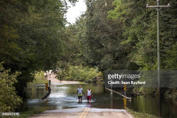 Matthew Cercy, left and Corey Rivera walk through flood waters caused by Hurricane Irma September 12, 2017 in Middleburg, Florida, United States. The...
