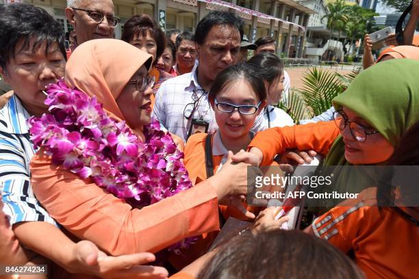 Singapore's new president-elect Halimah Yacob greets her supporters at the nomination centre in Singapore on September 13, 2017. An establishment...