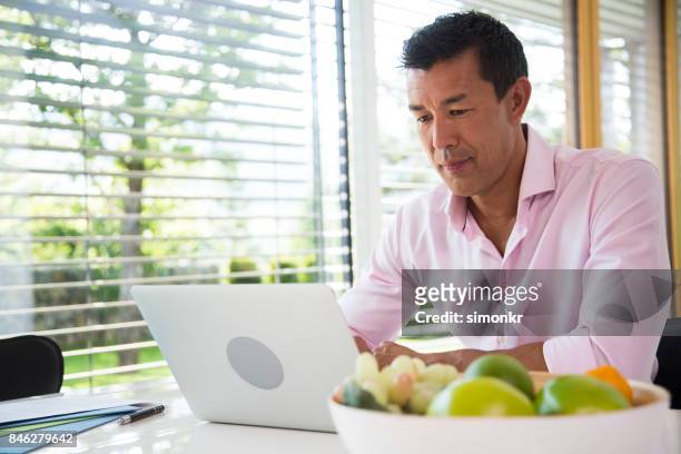 man using laptop - fruit bowl stock pictures, royalty-free photos & images
