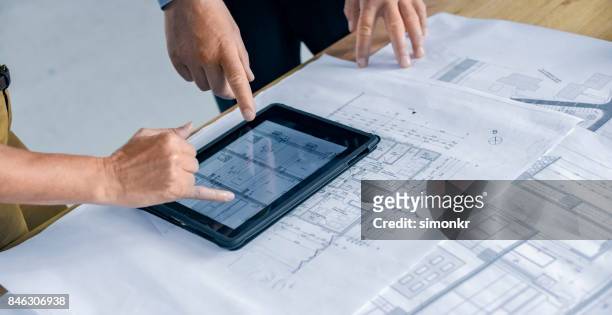 mannelijke en vrouwelijke architect met behulp van digitale tablet - architects design drawings stockfoto's en -beelden