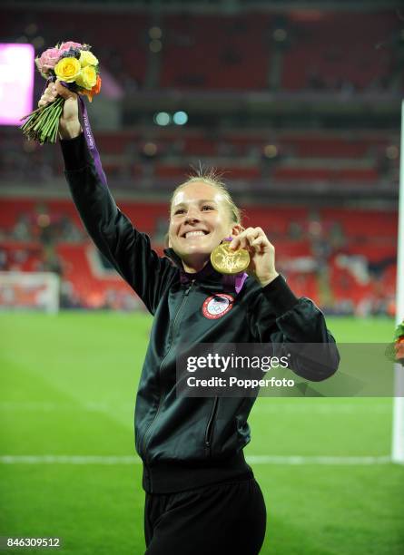 Rachel Buehler of the USA celebrates with her gold medal after her team defeat Japan in the Women's Football gold medal match on Day 13 of the London...