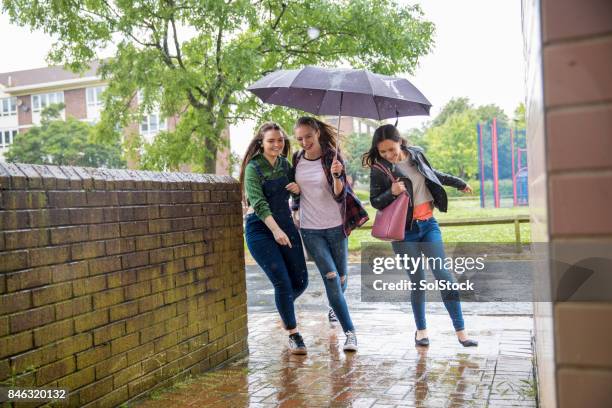 young women run in the rain - friendship over stock pictures, royalty-free photos & images