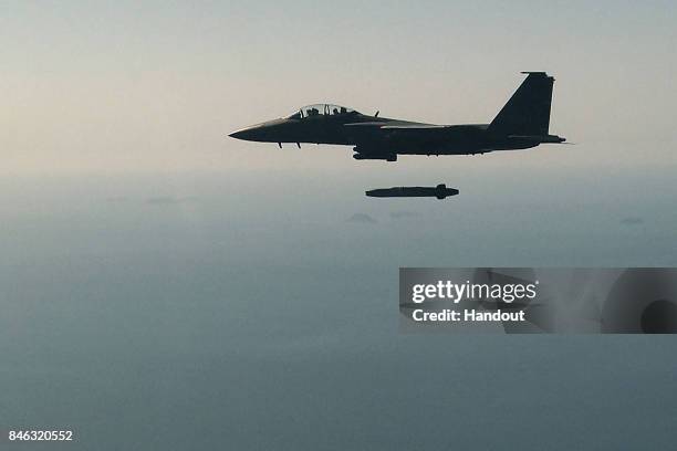 In this handout image provided by South Korean Defense Ministry, South Korean Air Force F-15K fighter jet flying with a Taurus long-range...