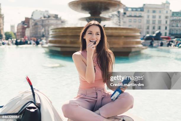 businesswoman eating biscuits in the city - woman chocolate stock pictures, royalty-free photos & images