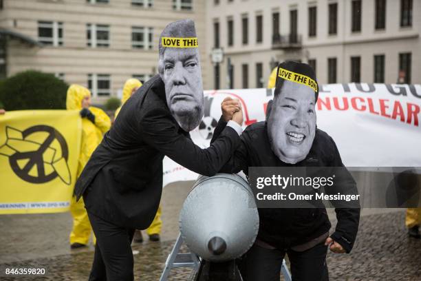 International campaign to abolish Nuclear Weapons activists wearing masks to look like US President Donald Trump and North Korean Kim Jong-Un pose...