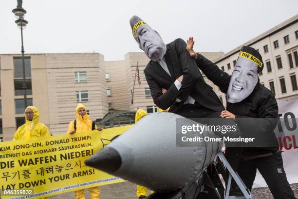 International campaign to abolish Nuclear Weapons activists wearing masks to look like US President Donald Trump and North Korean Kim Jong-Un pose...