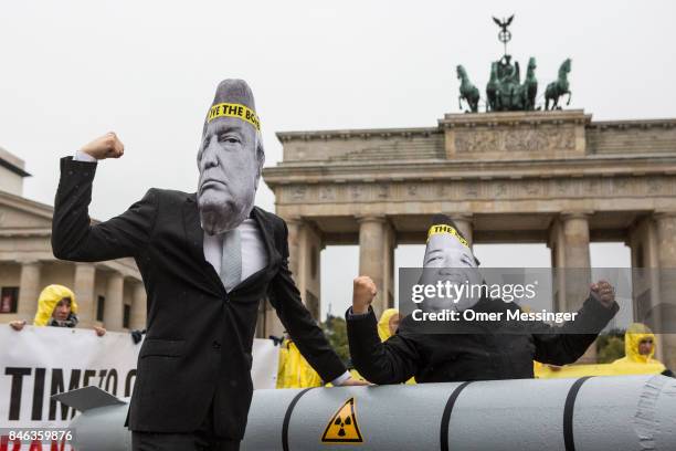 International campaign to abolish Nuclear Weapons activists wearing masks to look like US President Donald Trump and North Korean Kim Jong-Un pose...