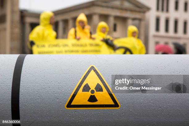 International campaign to abolish Nuclear Weapons activists wearing yellow hazard suits are seen next to a Styrofoam effigy of a nuclear bomb after...