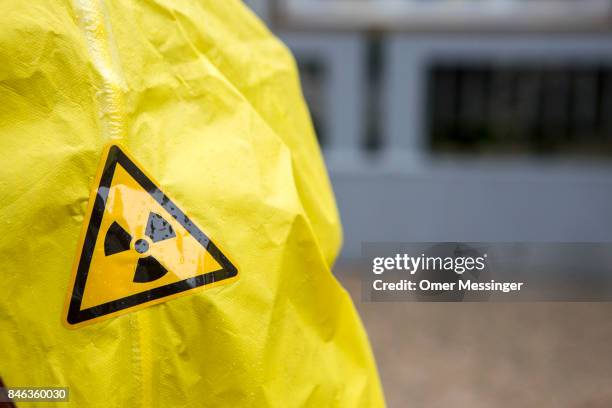 The nuclear hazard symbol is seen on An International campaign to abolish Nuclear Weapons activist's yellow suit during a protesting outside the...