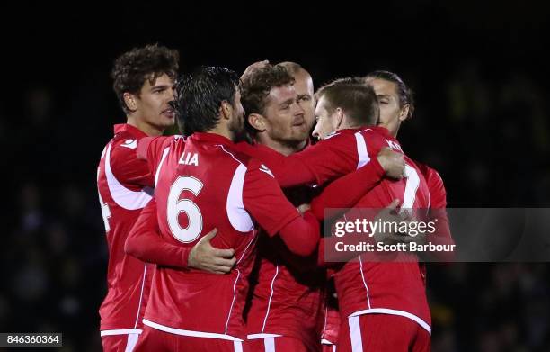 Nikola Mileusnic of Adelaide United is congratulated by his teammates after scoring a goal during the FFA Cup Quarter Final match between Heidelberg...