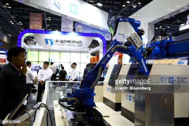 An attendee looks at industrial robots manufactured by Yaskawa Electric Corp. On display at the RobotWorld 2017 industry show in Goyang, South Korea,...