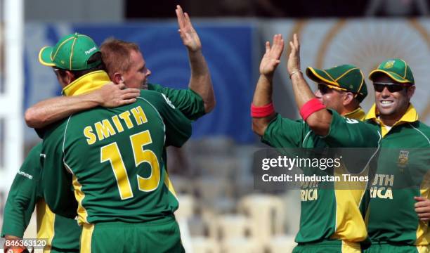 South Africa's Shaun Pollock celebrates with captain Graeme Smith and teammates after taking the wicket of New Zealand's Lou Vincent during a match...