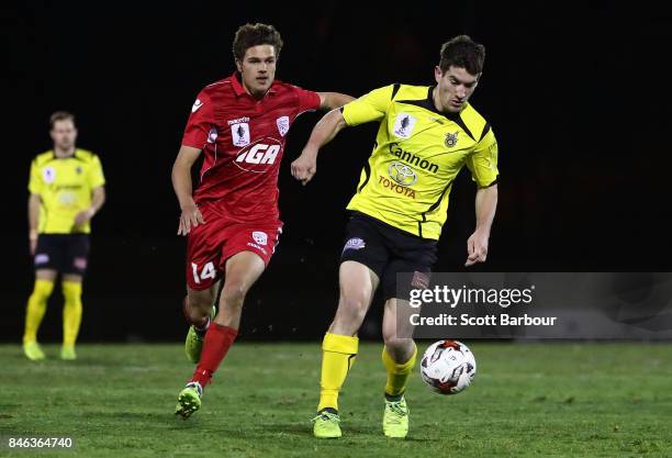Joshua Wilkins of Heidelberg United FC and George Blackwood of Adelaide United competes for the ball during the FFA Cup Quarter Final match between...