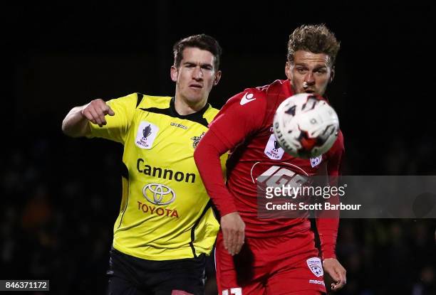 Joshua Wilkins of Heidelberg United FC and Johan Absalonsen of Adelaide United compete for the ball during the FFA Cup Quarter Final match between...