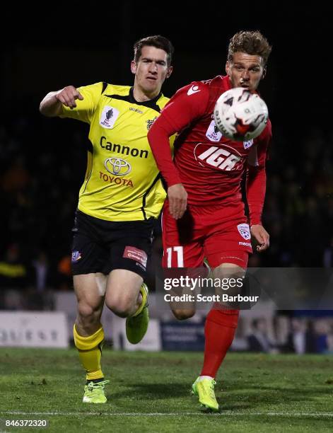 Joshua Wilkins of Heidelberg United FC and Johan Absalonsen of Adelaide United compete for the ball during the FFA Cup Quarter Final match between...