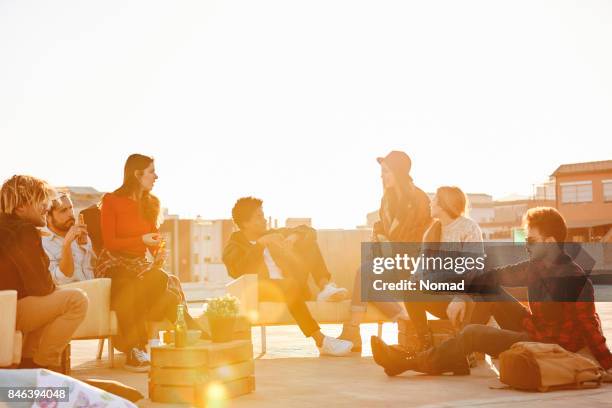 amici che si godono sulla terrazza degli edifici in estate - terrazza foto e immagini stock