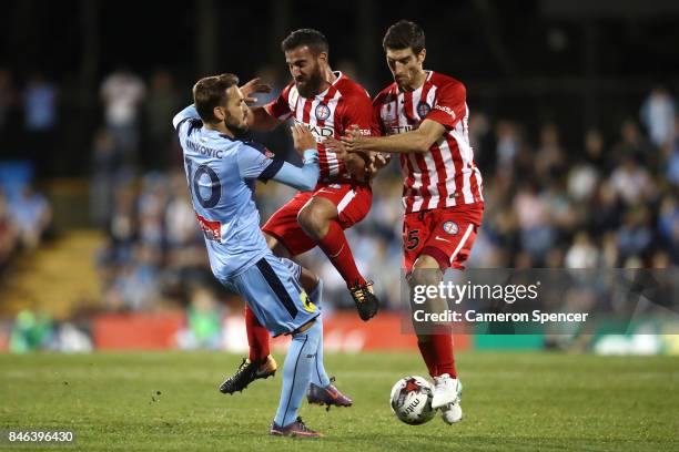 Milos Ninkovic of Sydney FC collides with Emmanuel Muscat of City FC and Iacopo La Rocca of City FC during the FFA Cup Quarter Final match between...