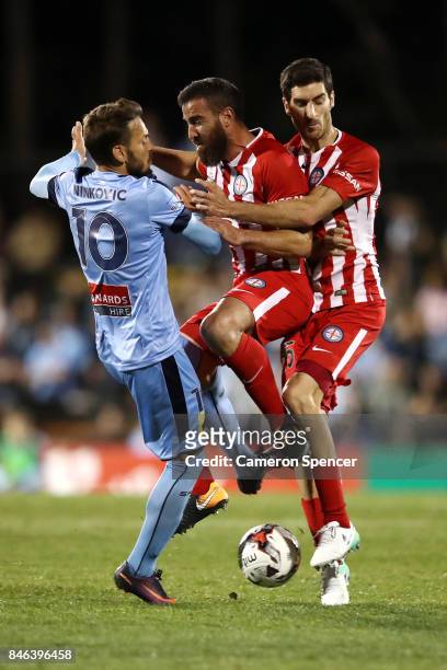 Milos Ninkovic of Sydney FC collides with Emmanuel Muscat of City FC and Iacopo La Rocca of City FC during the FFA Cup Quarter Final match between...
