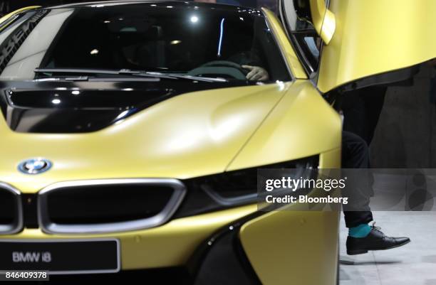 An attendee steps out from from the butterfly door of BMW i8 electric automobile, manufactured by Bayerische Motoren Werke AG , during the second...