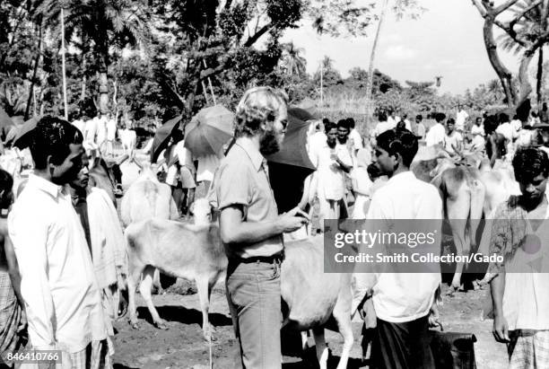 Jeff Koplan, MD MPH among a group of native villagers and animals during a smallpox eradication effort in Bangladesh, 1970. Image courtesy CDC.