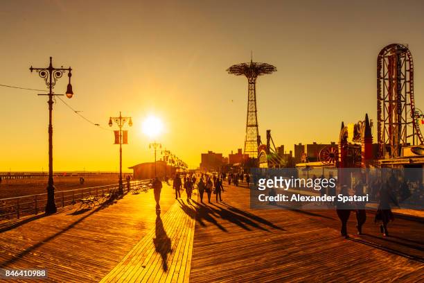 the coney island boardwalk at sunset, brighton beach, brooklyn, new york city, ny, usa - uferpromenade stock-fotos und bilder