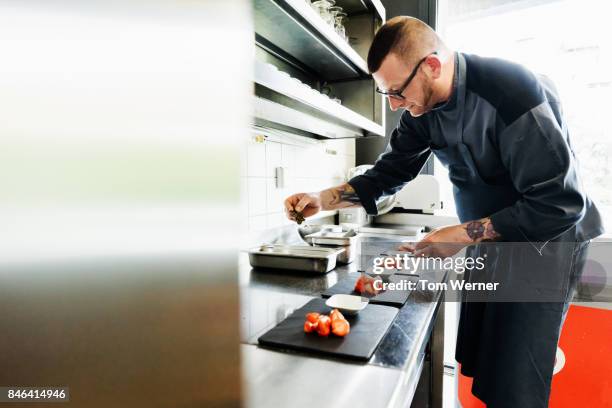 head chef carefully preparing starters in restaurant kitchen - häppchen stock-fotos und bilder