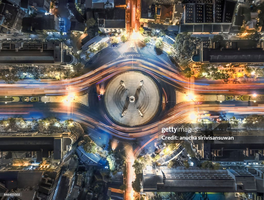 Aerial top view traffic circle with speed light in city at night , Democracy Monument , bangkok , thailand .