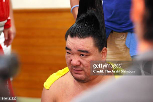 Mongolian yokozuna Harumafuji responds to questions while has his topknot arranged after his defeat by Hokutofuji in the dressing room during day...