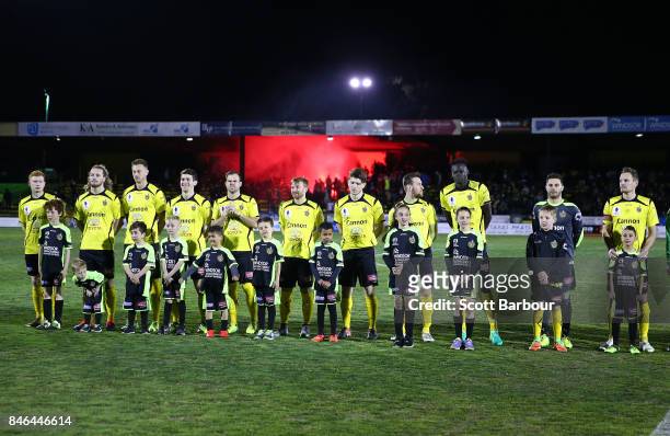 Heidelberg United FC line up as a flare is let off in the crowd during the FFA Cup Quarter Final match between Heidelberg United FC and Adelaide...