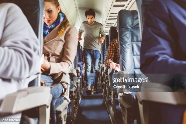 people traveling by airplane - aisle seat airline stock pictures, royalty-free photos & images