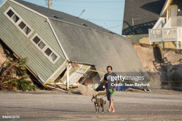 Jose Orosz walks his dog Karen by a beachfront home destroyed by Hurricane Irma on September 13, 2017 in Vilano Beach, Florida. Nearly 4 million...