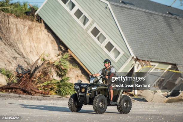 Sheriff's officer passes by a beachfront home destroyed by Hurricane Irma on September 13, 2017 in Vilano Beach, Florida. Nearly 4 million people...