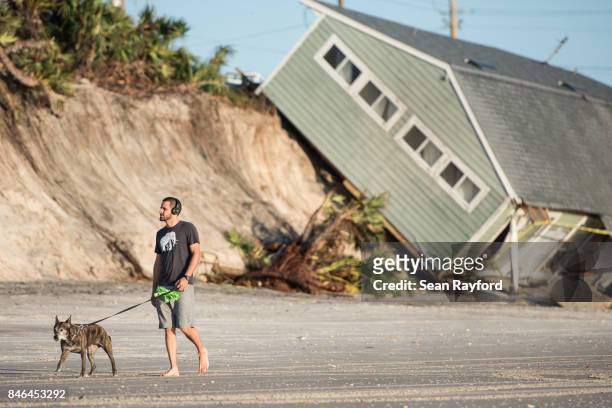 Jose Orosz walks his dog Karen by a beachfront home destroyed by Hurricane Irma on September 13, 2017 in Vilano Beach, Florida. Nearly 4 million...