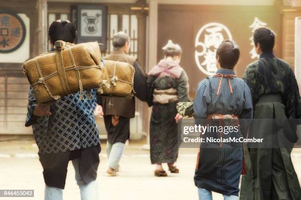 rear view of small group of japanese actors reenacting edo period village scene - historical reenactment stock pictures, royalty-free photos & images