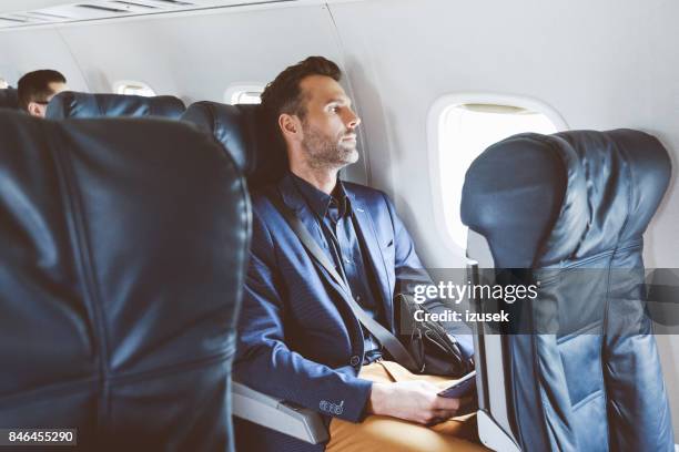 zakenman met het vliegtuig vliegen - window seat stockfoto's en -beelden