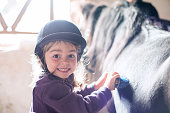 Little girl brushing her pony
