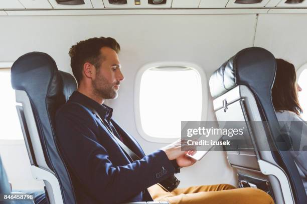 empresario con tableta digital en avión - aircraft wifi fotografías e imágenes de stock