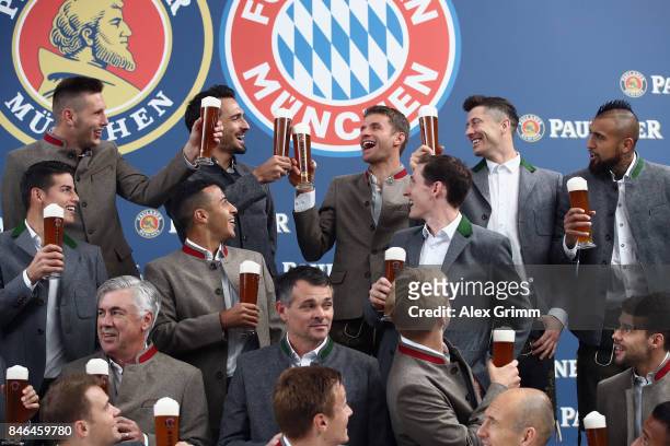 Team mates raise a birthday toast to Thomas Mueller during the FC Bayern Muenchen Paulaner photo shoot in traditional Bavarian lederhosen on...