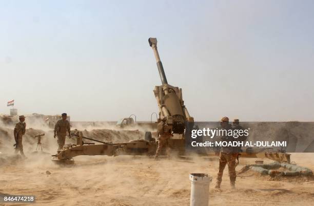 Iraqi forces fire preliminary shells from the area of al-Sakrah, as they prepare a military operation to push out Islamic State group jihadists from...